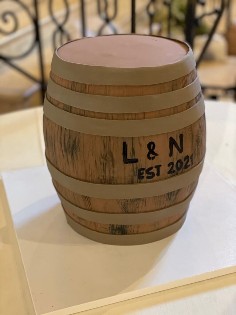 realistic large whiskey barrel grooms cake in brown and black wood grain