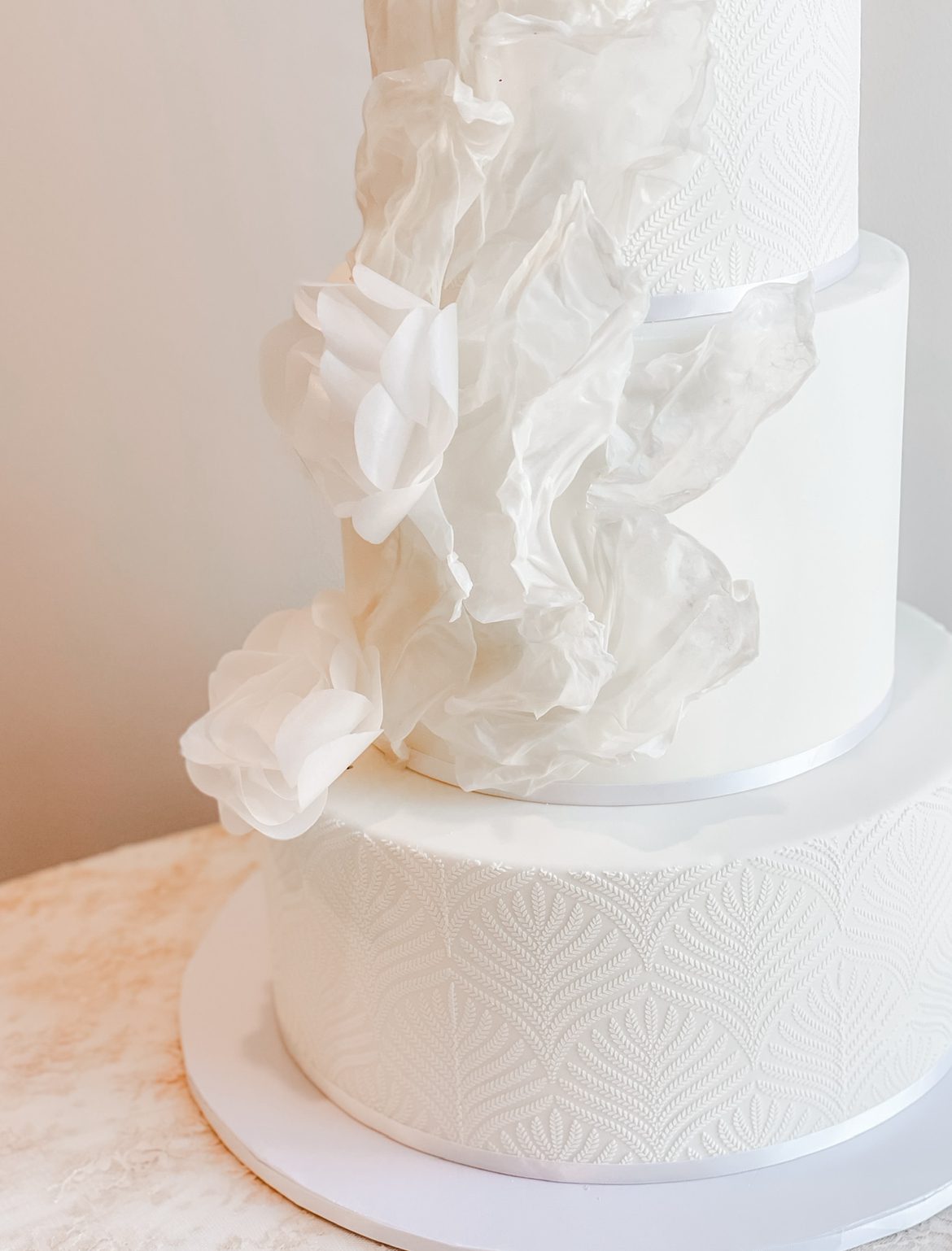 luxury modern wedding cake with white sails and white paper flowers